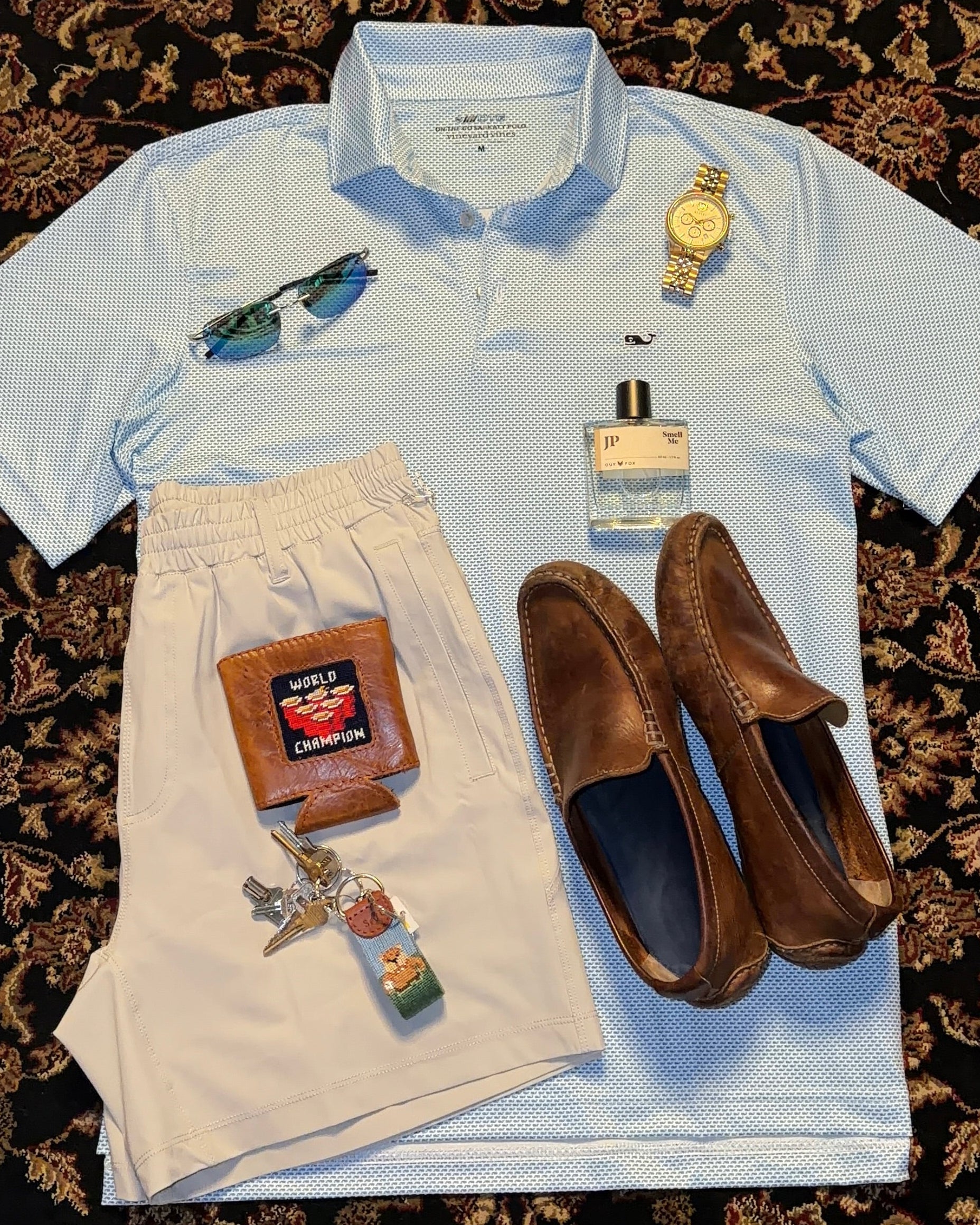 Collection of men's clothing and accessories on a patterned rug vineyard vines ssco guy fox smathers and branson 