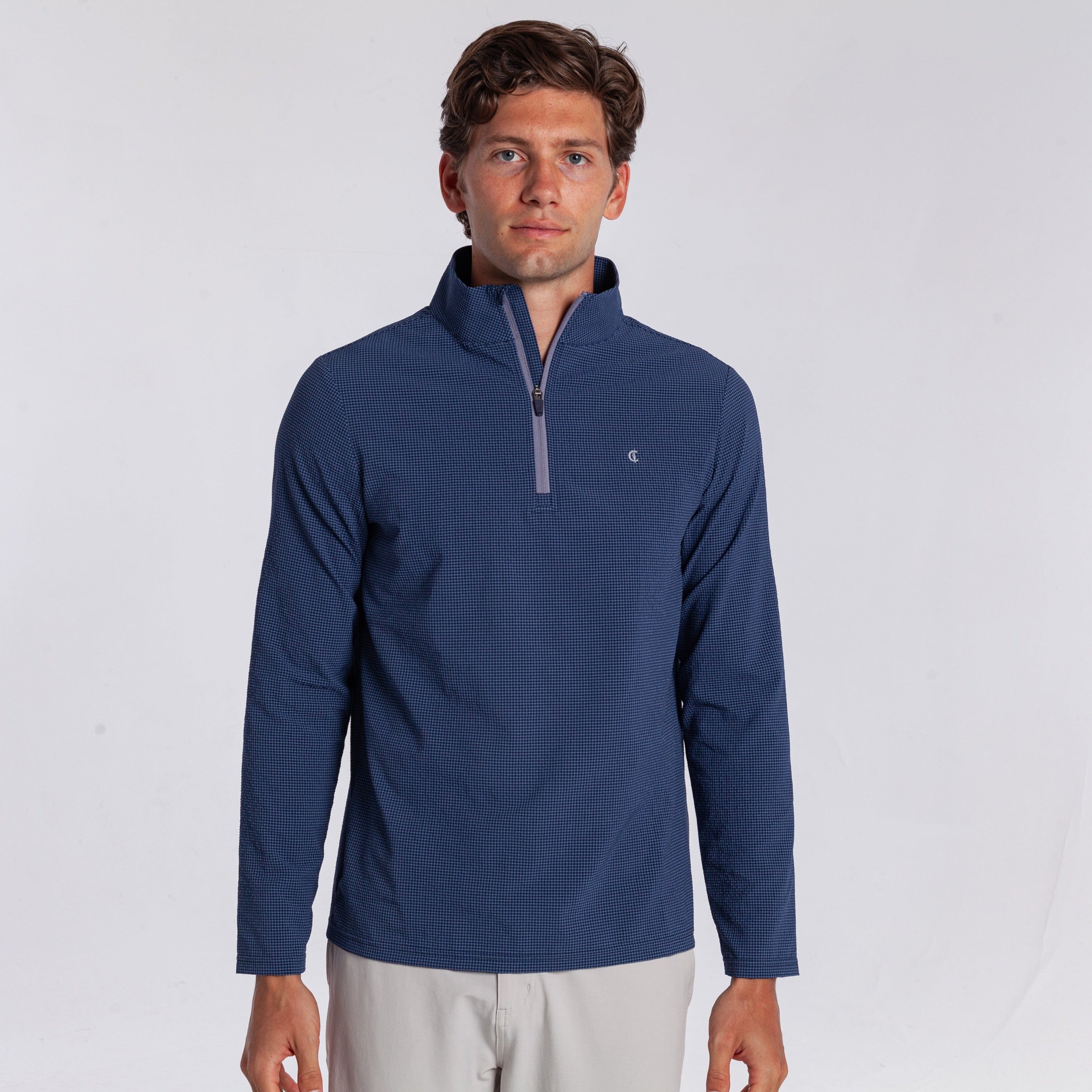 Man wearing a blue pullover with a quarter zip on a white background